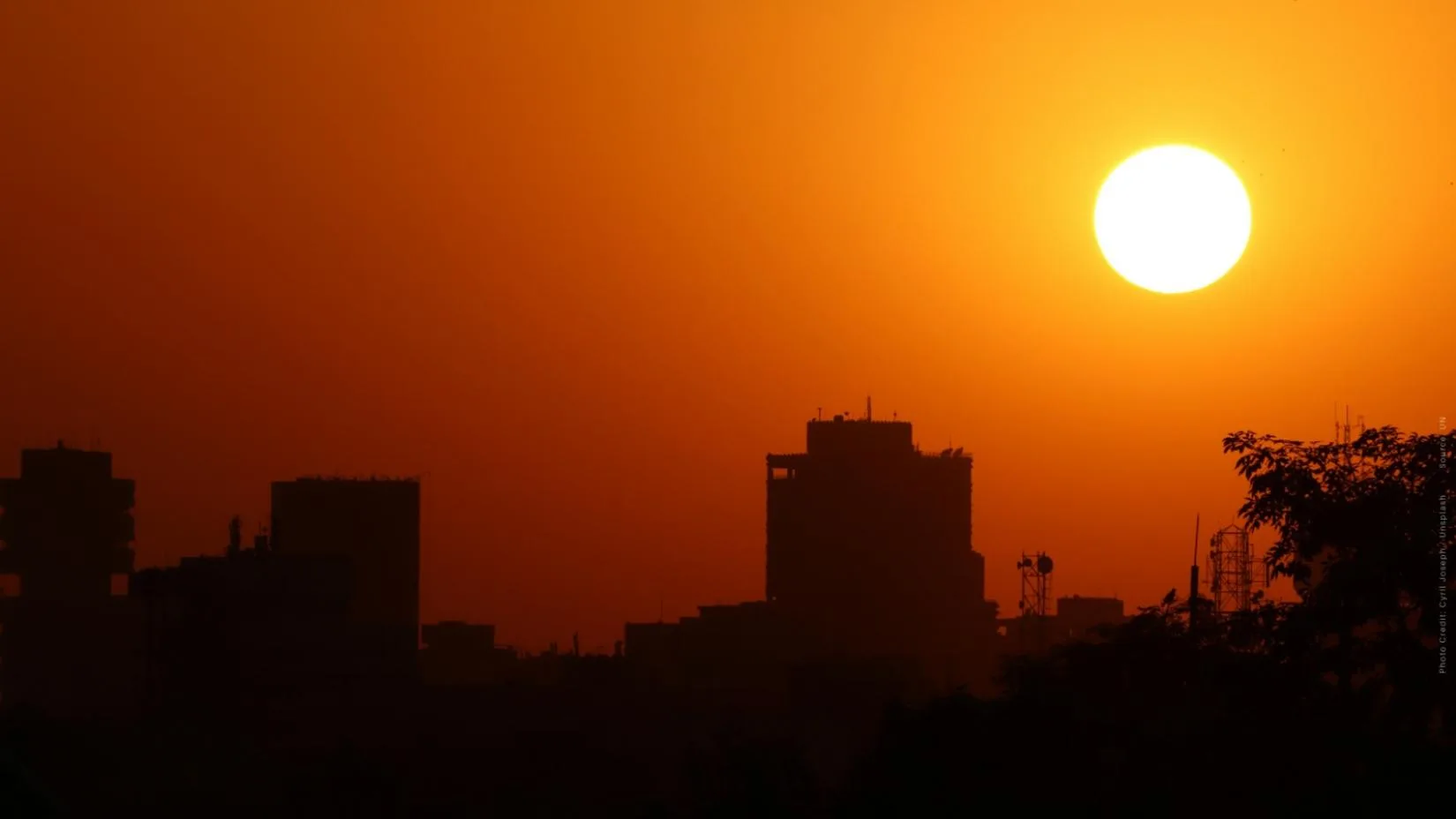 Pessoas de diferentes idades segurando cartazes e participando de um mutirão de conscientização e ação climática em uma praça pública.